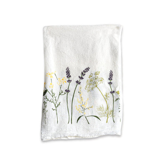 A June & December branded white tea towel with herb and flower designs.