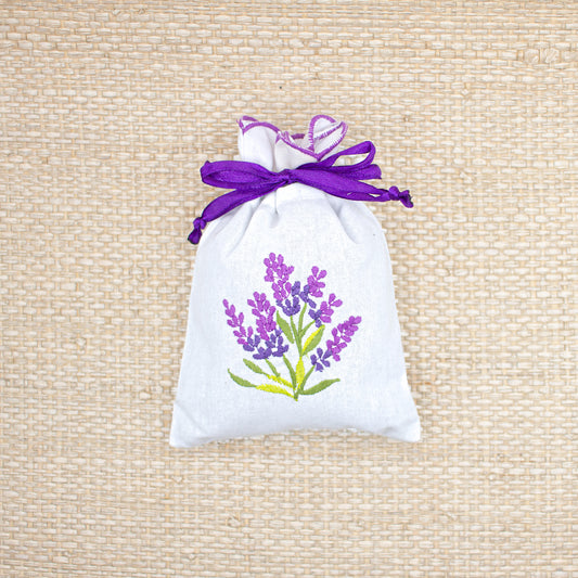 Lavender sachet with lavender embroidery and a purple ribbon.
