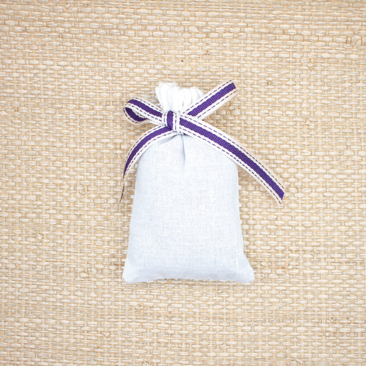 Small lavender sachet in white, plain cotton bags tied with a purple and white ribbon.