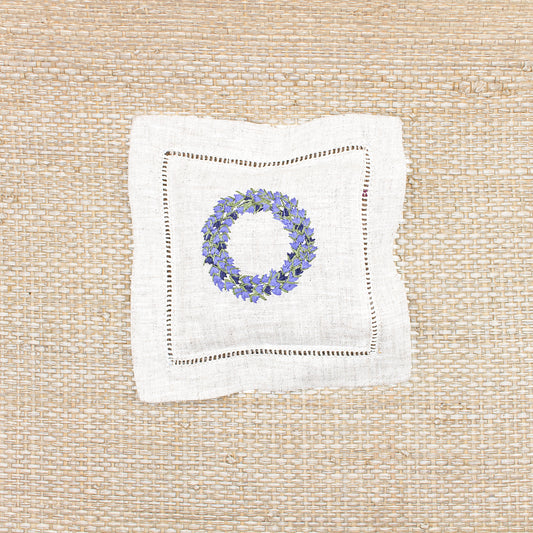 A single square lavender sachet with a lavender ring embroidered on the top if it.